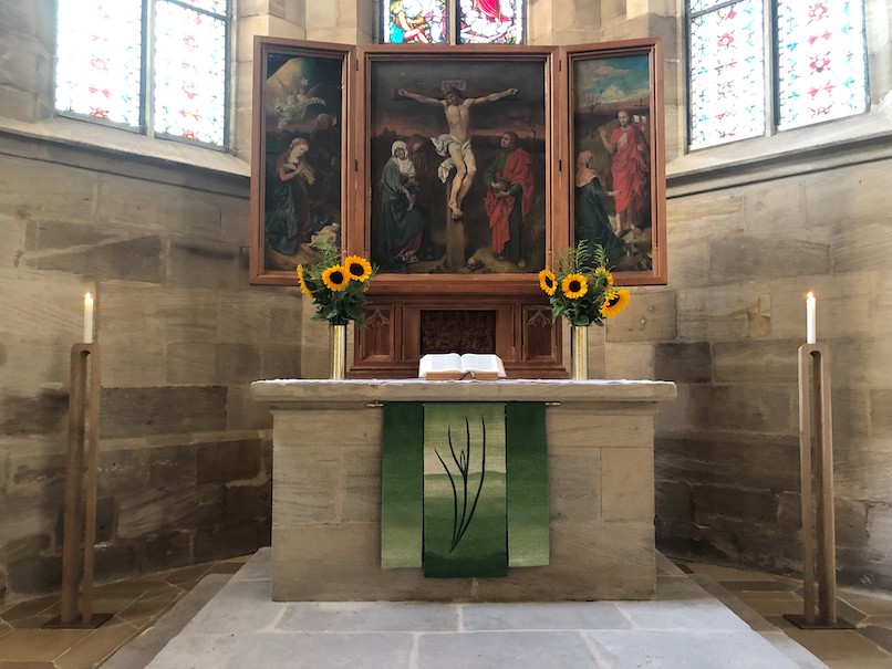 Renovierter Altar geschmückt mit Sonnenblumen, behängt mit Parament und Kerzenständern zu den Seiten