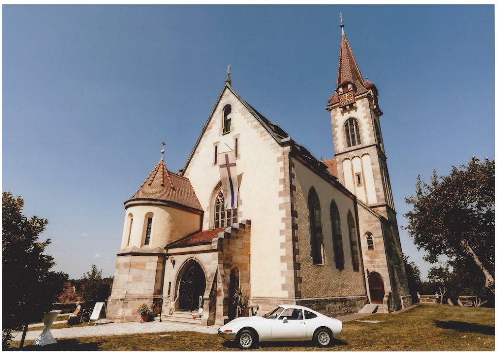 St. Jakobuskirche im Sommer mit Hochzeitsauto im Vordergrund